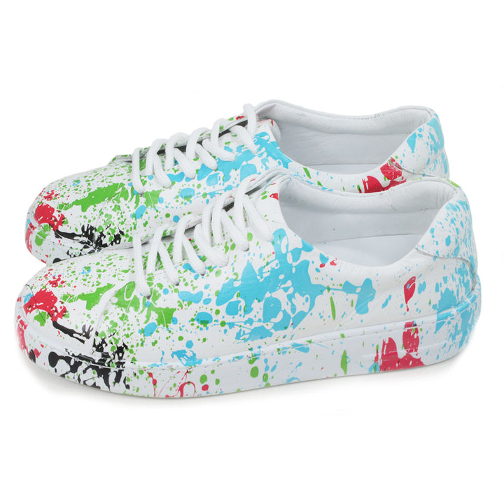 Leather white trainers with paint splash decoration. Six hole lace ups. Side view.