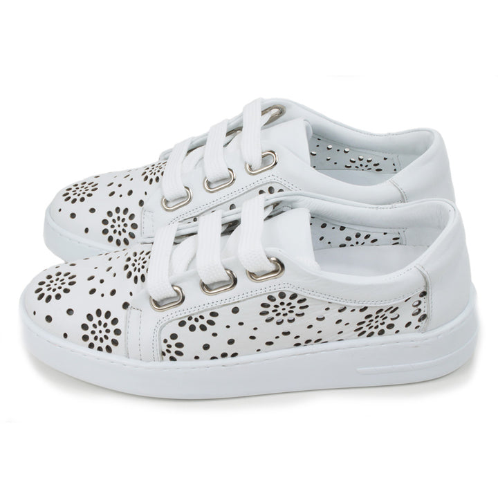 White training shoes with white rubber soles. Punched holes patterns over the entire shoes. Three holes while flat laces. Side view.