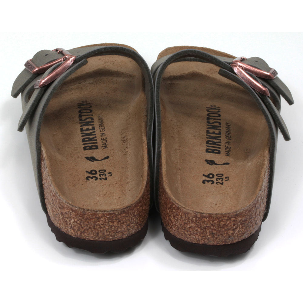 Birkenstock stone coloured Arizona sandals. Two straps over foot adjusted by copper coloured buckles. Open back. Sculpted cork  soles and footbed. Back view.