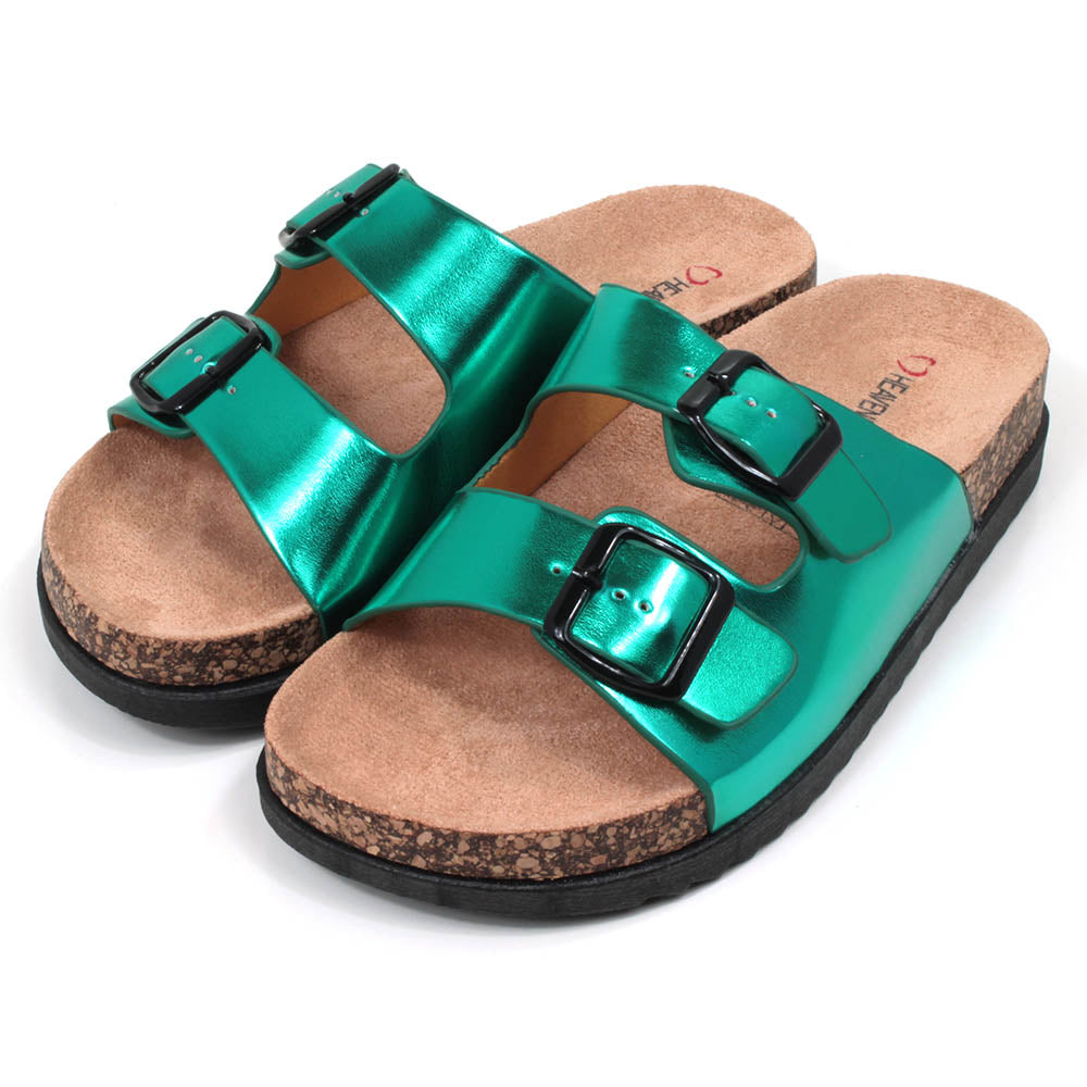 Metallic effect jade green double strap open backed sandals. Adjustments by black buckles. Cork effect, sculpted soles and footbeds. Angled view. 