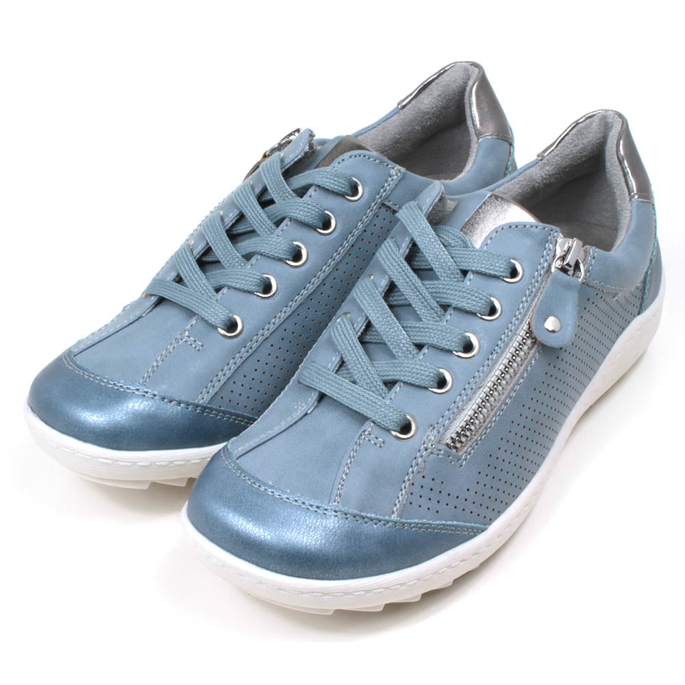 Mid blue trainers with white soles. Matching laces for adjustment and side zip for fitting. Silver detailing on the tongue and at the heels. Angled view.