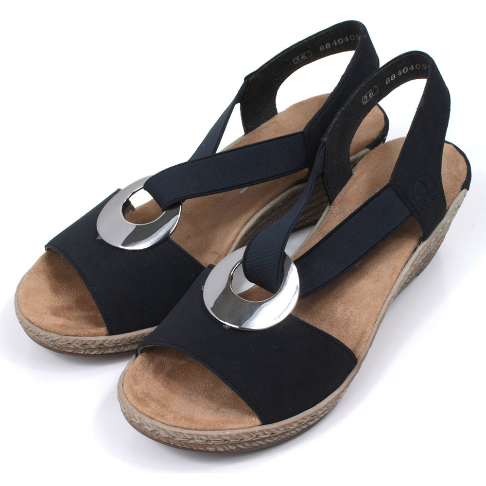 Rieker navy blue peep toe sandals. Mid height heels. Silver ring connection ankle strap. Elasticated ankle strap in matching navy. Angled view.