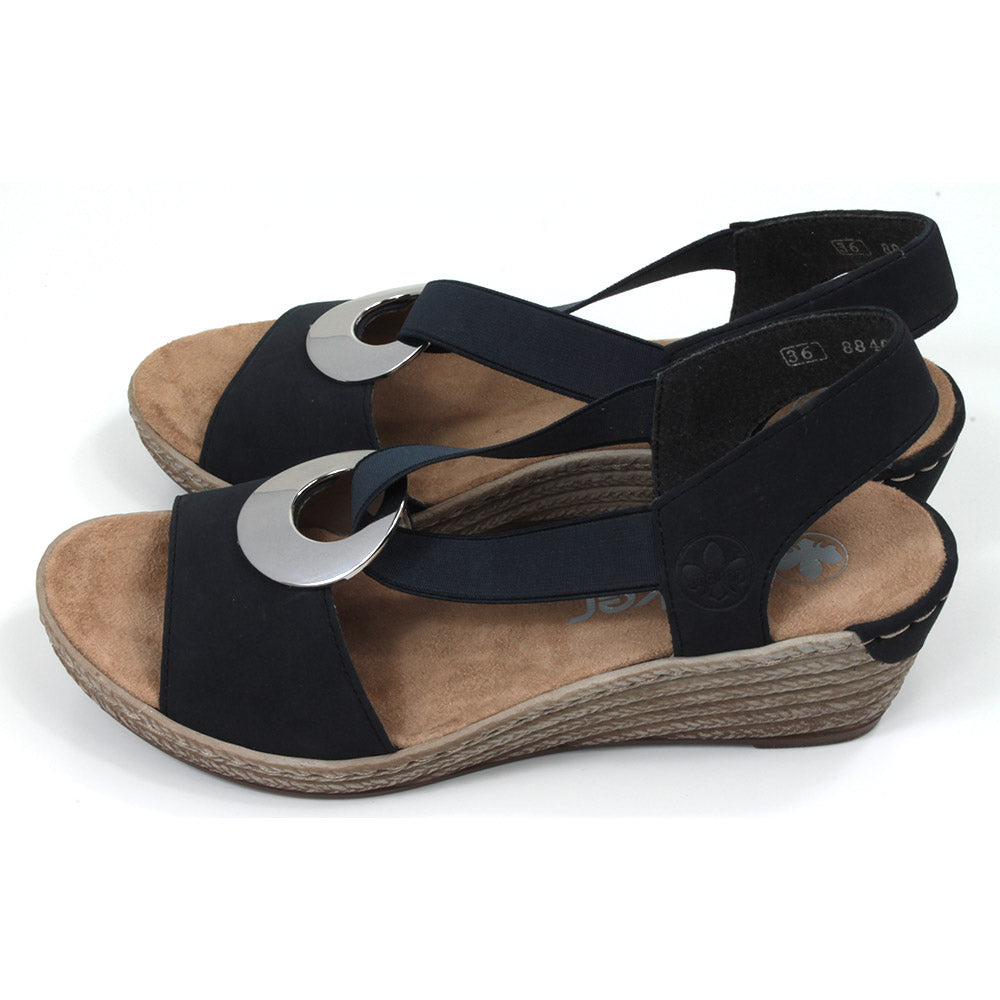 Rieker navy blue peep toe sandals. Mid height heels. Silver ring connection ankle strap. Elasticated ankle strap in matching navy. Side view.