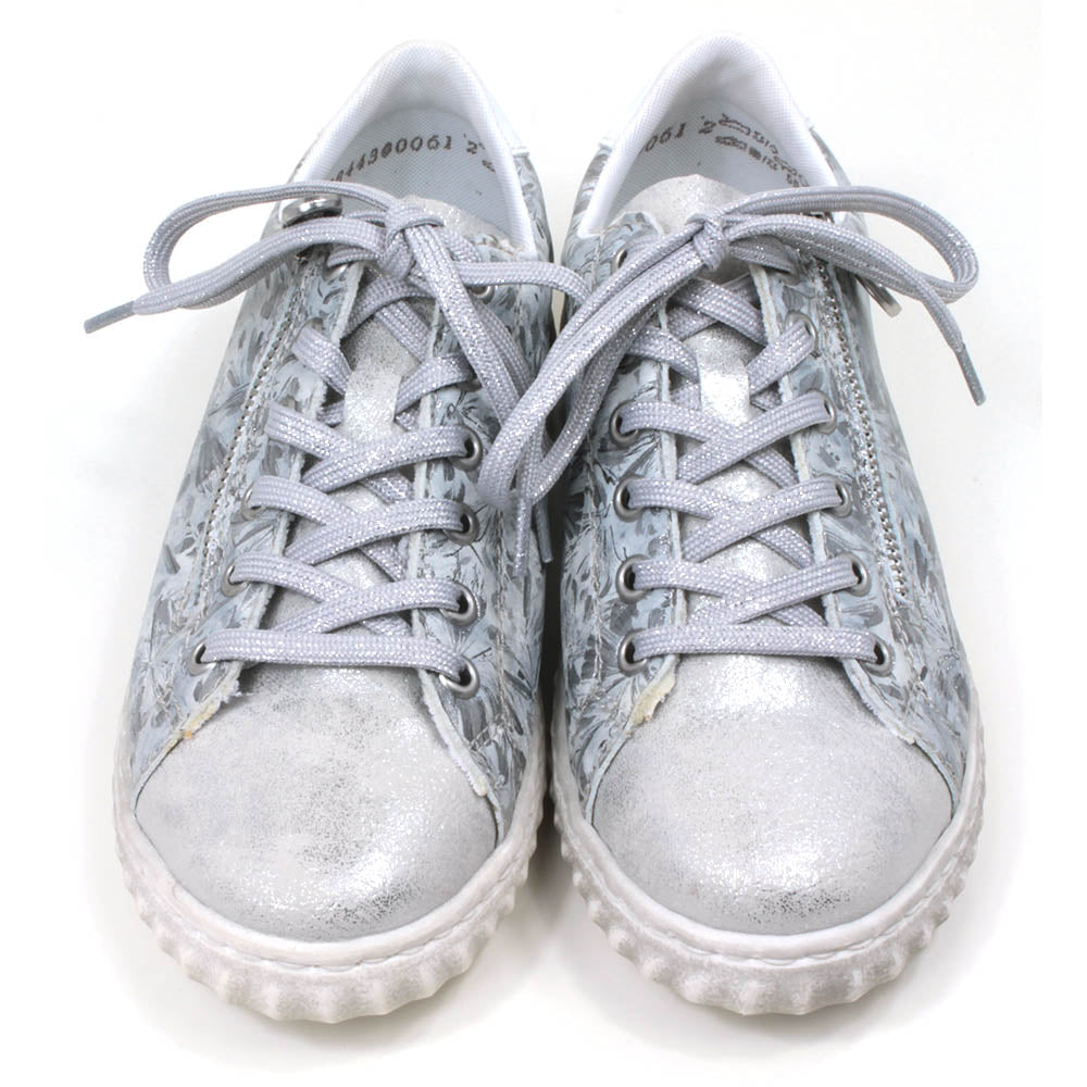 Rieker trainers in silver floral pattern. Lace up adjustment and zip fitting. Front view.