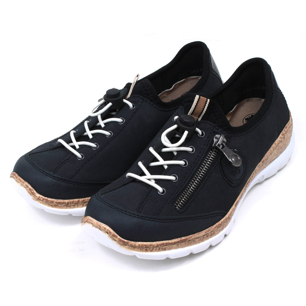 Rieker navy blue trainers. White laces and zip down outside of the foot. White soles with cork effect detail. Shoes shown at an angle.
