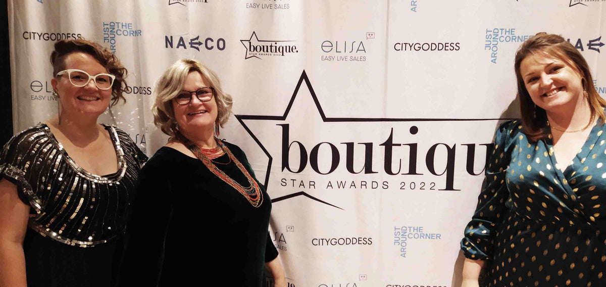 Trueman, Caroline and Ella posing by the Boutique Star Awards 2022 banner.