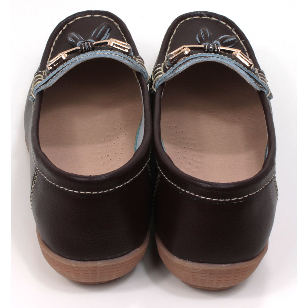 Joe and Jo moccasin style slip on, leather shoes in chocolate colour. Over the foot metallic gold coloured  detail and two matching tassels. Beige rubber soles. Back view.