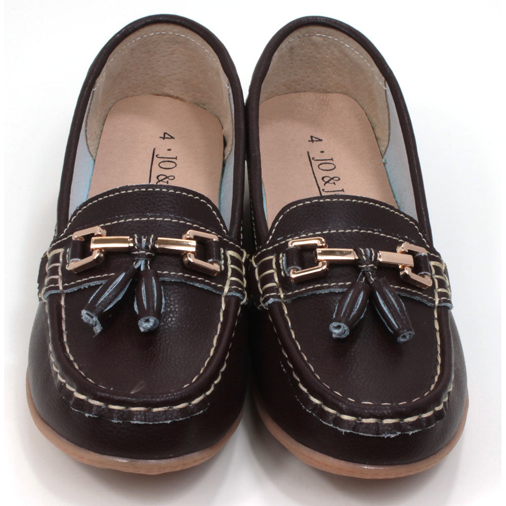 Joe and Jo moccasin style slip on, leather shoes in chocolate colour. Over the foot metallic gold coloured  detail and two matching tassels. Beige rubber soles. Front view.