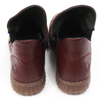 Low ankle boots in wine red colour. Leather effect with red stitching. Zip fitting using black zips. Contrasting colour material details on the sides with faux lacing. Rubber soles. Back view.