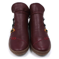 Low ankle boots in wine red colour. Leather effect with red stitching. Zip fitting using black zips. Contrasting colour material details on the sides with faux lacing. Rubber soles. Front view.