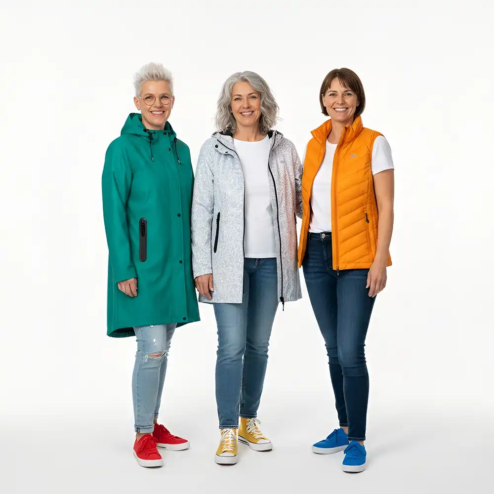 Three women wearing colorful jackets and jeans on a white background