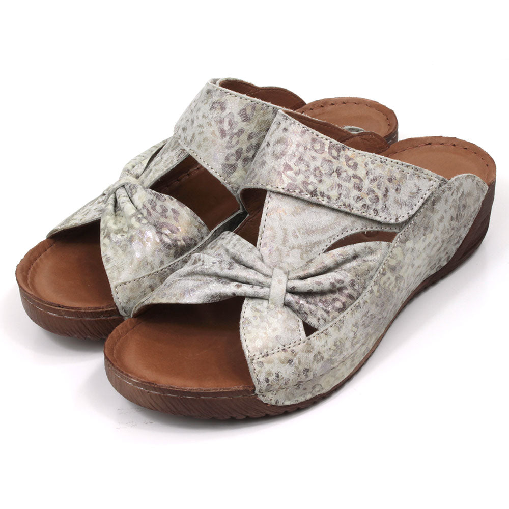 Adesso Lexi mule sandals. Low heels. Over the foot bow design in big cat print. Angled view.