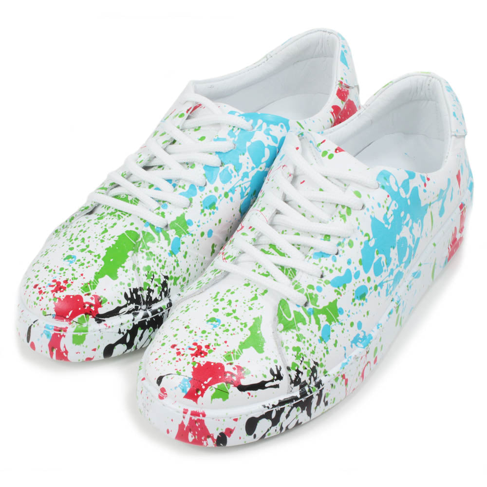 Leather white trainers with paint splash decoration. Six hole lace ups. Angled view.