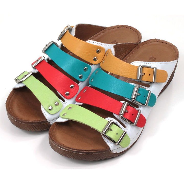 Adesso Zuri rainbow straps sandals. Four straps over the foot in mustard, teal, red and green. White leather upper. Low heels. Angled view.