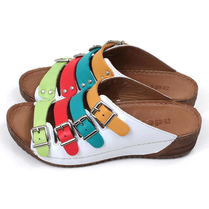 Adesso Zuri rainbow straps sandals. Four straps over the foot in mustard, teal, red and green. White leather upper. Low heels. Side view.