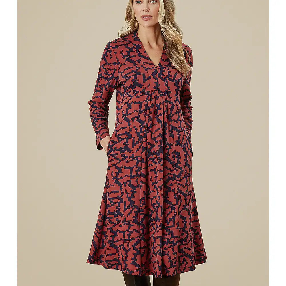 Woman wearing a red and black patterned dress on a beige background