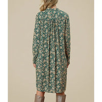 Woman wearing a floral dress with long sleeves on a beige background