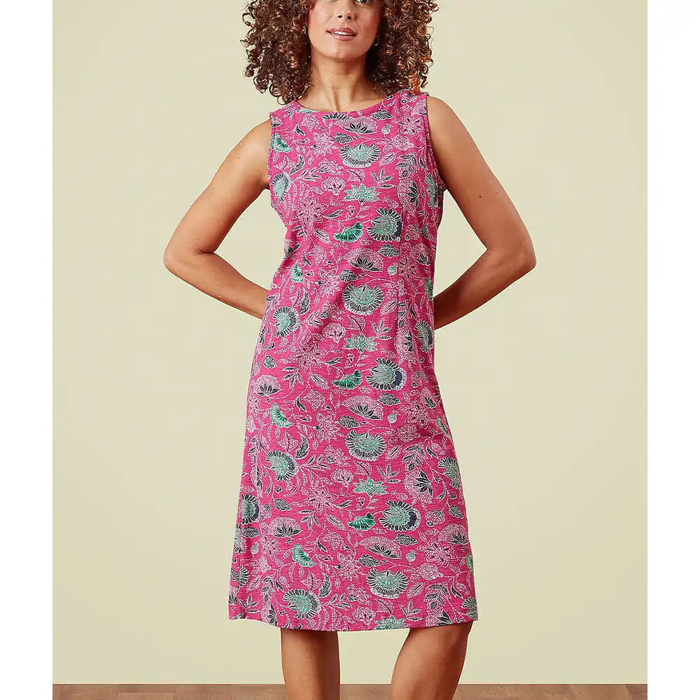 Woman wearing a pink dress with hedgehog pattern against a beige background