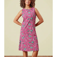 Woman wearing a pink dress with hedgehog pattern against a beige background