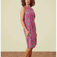 Woman wearing a pink patterned dress against a beige background