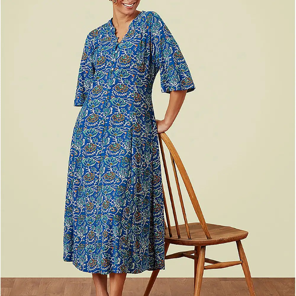 Blue patterned dress with elbow length bell sleeves and v neckline.