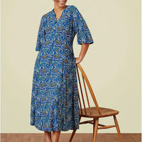 Blue patterned dress with elbow length bell sleeves and v neckline.