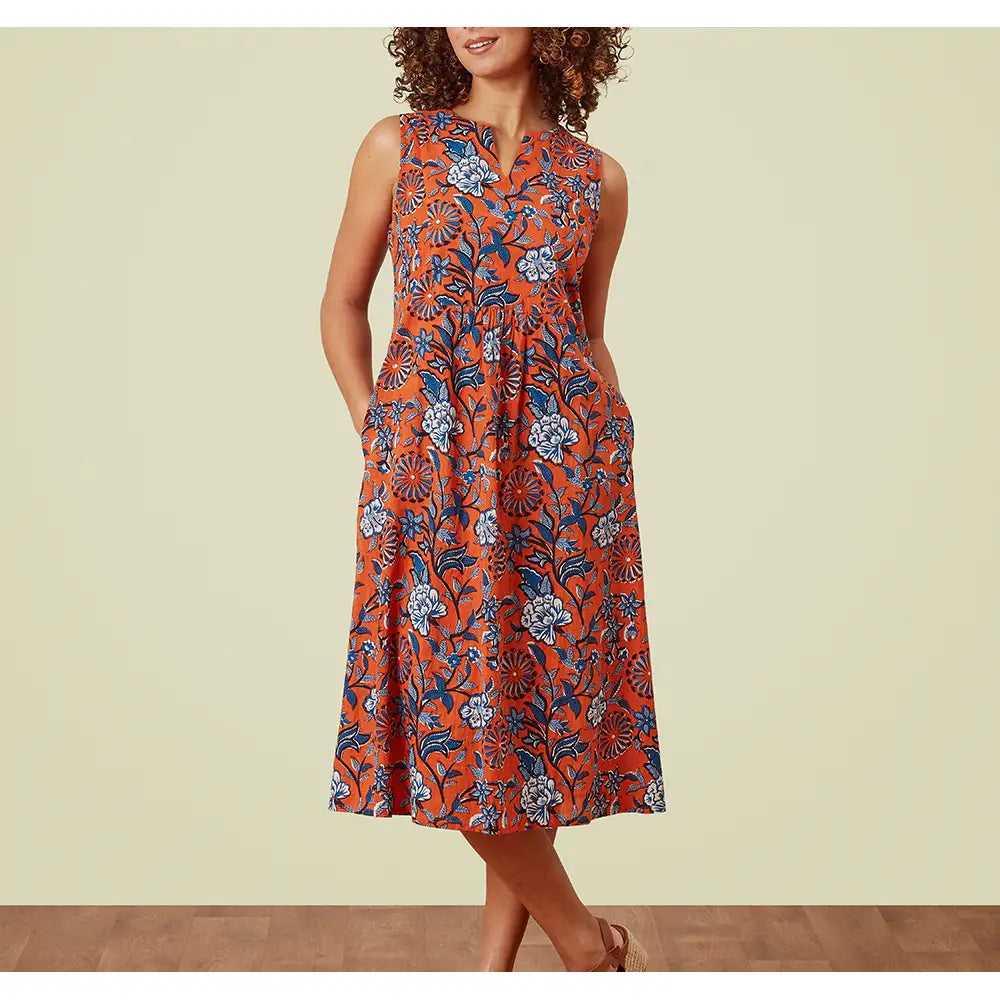 Sleeveless notch neck orange dress with blue floral print all over. Hip pockets and falling to the knee. 