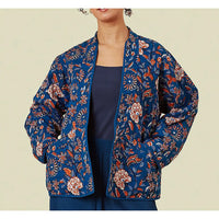 Woman wearing an blue floral kimono on a beige background. 