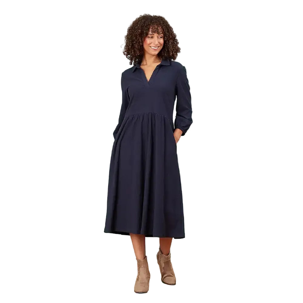 A woman modeling a dark navy blue long-sleeve midi dress with a V-neckline and side pockets, standing against a solid white background.