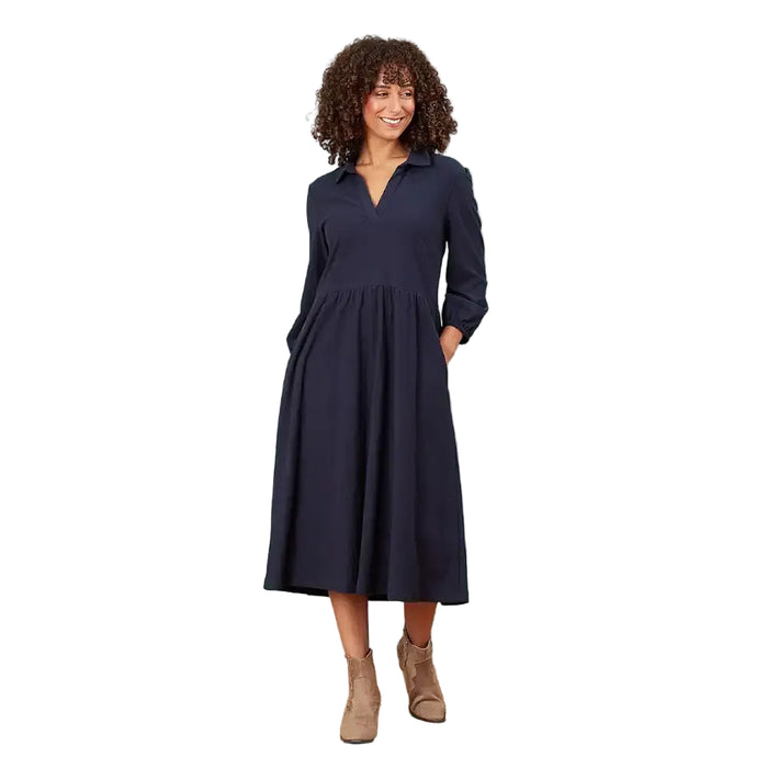 A woman modeling a dark navy blue long-sleeve midi dress with a V-neckline and side pockets, standing against a solid white background.