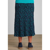 Back of Midcalf length navy and ade green spotted A line skirt with navy Chelsea boots