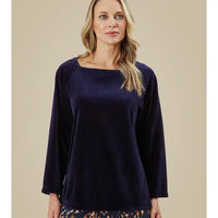 Woman wearing a navy blue top against a beige background