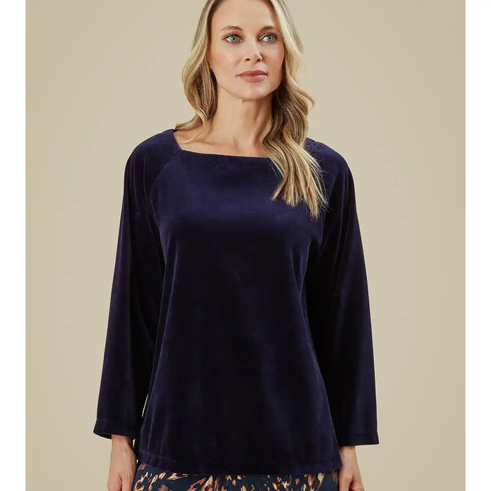 Woman wearing a navy blue top against a beige background