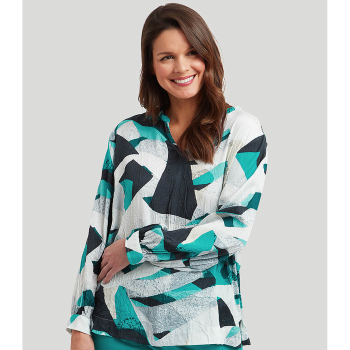 The front of a geometric print crush fabric top with long gathered sleeves and a wide notch neckline. Featuring bright turquoise, black, white and beige. 