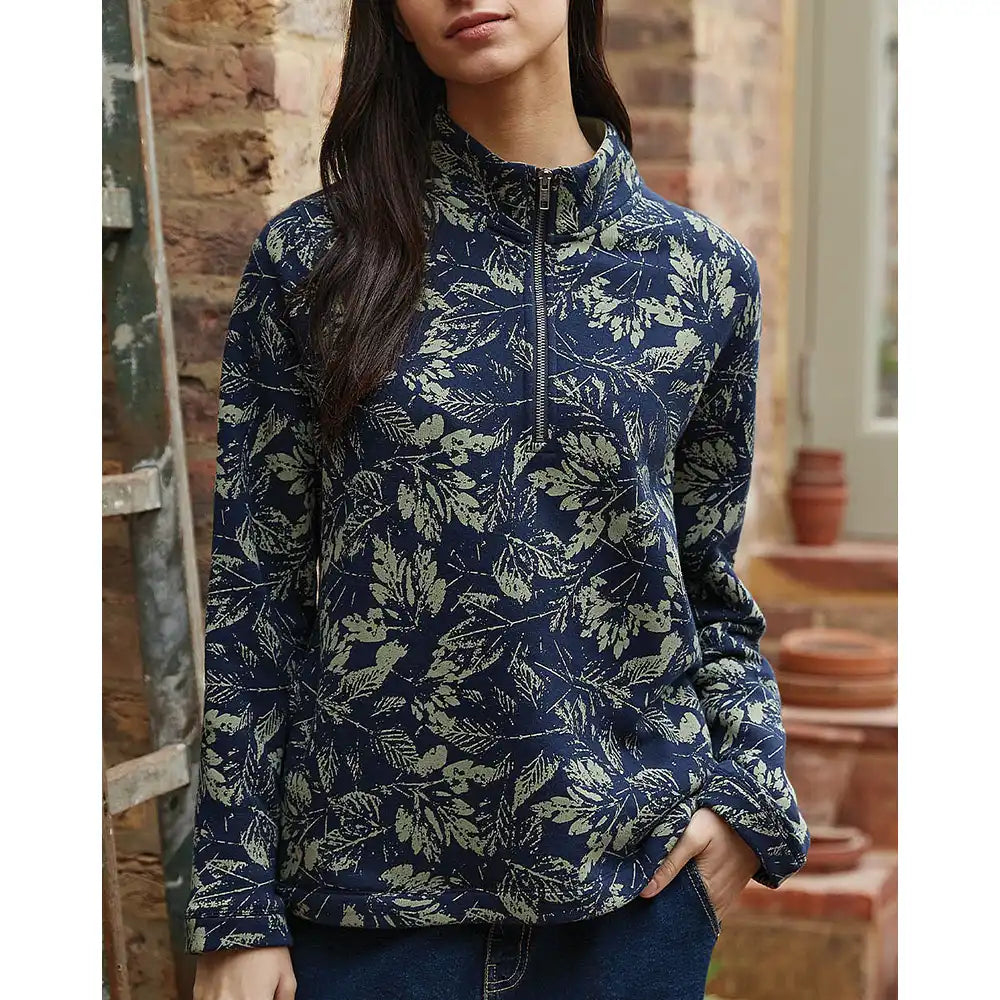 Person wearing a blue floral patterned pullover in an indoor setting.