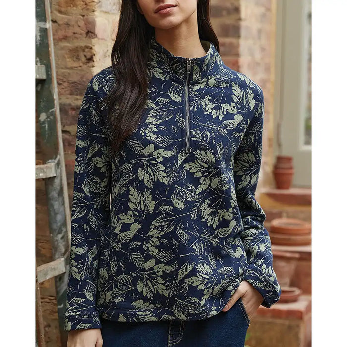 Person wearing a blue floral patterned pullover in an indoor setting.