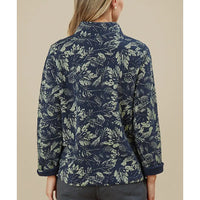 Person wearing a navy blue floral patterned shirt against a beige background