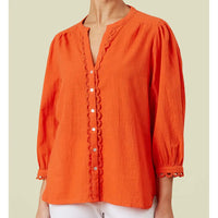 Orange shirt with Notch neckline, silver buttons up the front with frill detailing. Gathered 3/4 length sleeve with lace trim. 