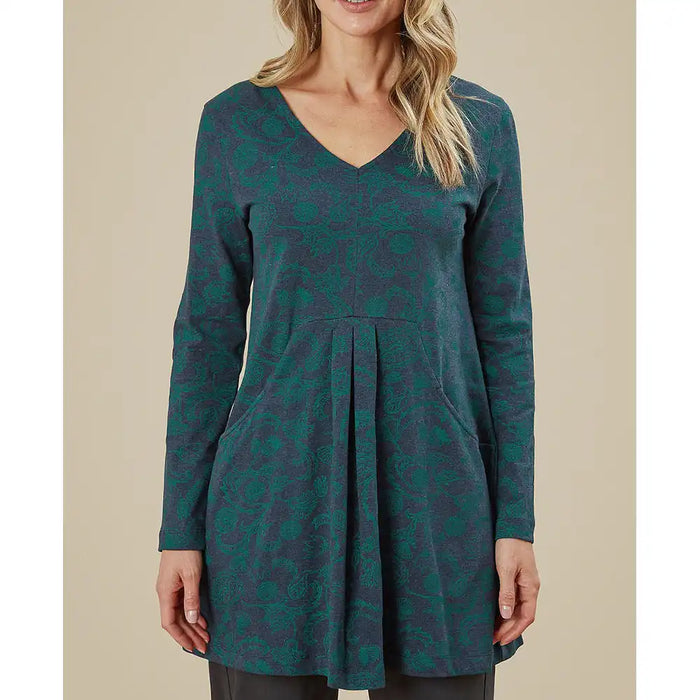 Green patterned dress worn by a person on a beige background