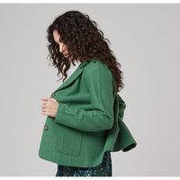 Side of bright green woolen jacket with long sleeves, patch pocket and buttons for fastening. 