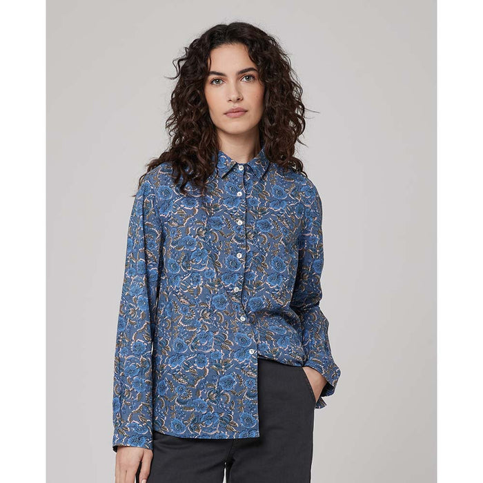 Crinkle fabric with a busy floral print on a blue background. Long sleeves, front buttoning and shirt collar.