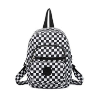 Small fabric backpack with black and white checkerboard design. Zipped pockets.
