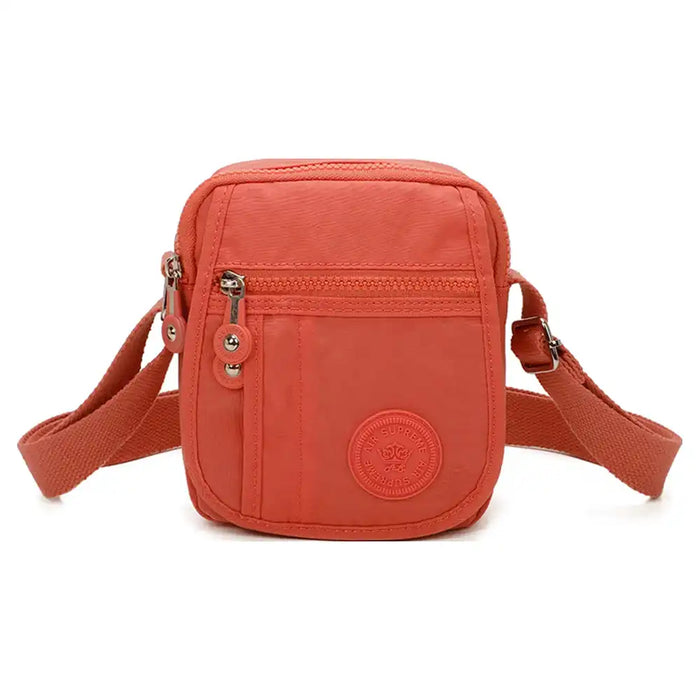 Small orange cross body satchel. Flap over and zipper closing. Matching orange strap.