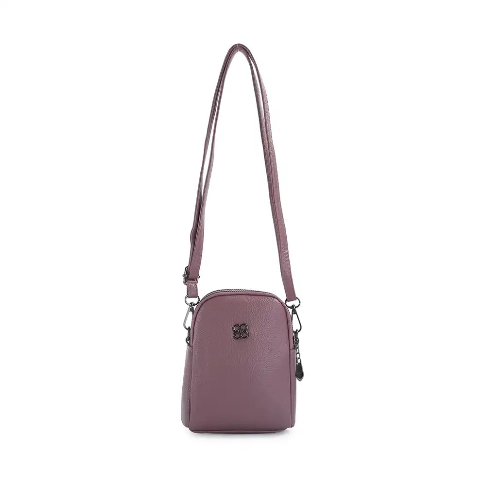 A small, dome-shaped crossbody bag in a dusty mauve purple color, featuring a matching adjustable shoulder strap, a front zippered pocket, and a small black metal logo emblem on the front, set against a plain white background.