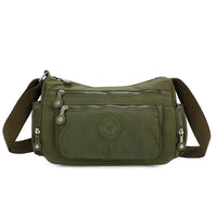 Green shoulder bag with multiple pockets and zippers on a white background