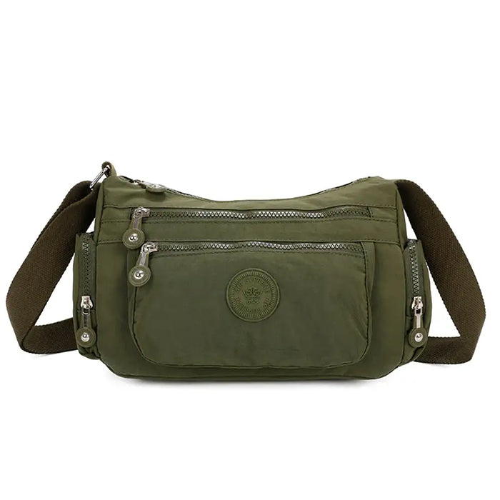 Green shoulder bag with multiple pockets and zippers on a white background