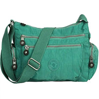 Green shoulder bag with multiple zippers on a white background