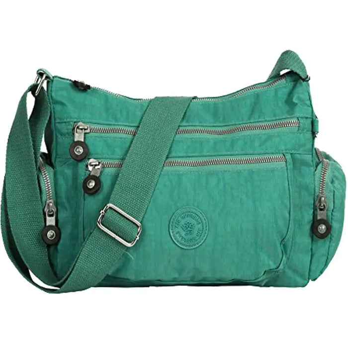 Green shoulder bag with multiple zippers on a white background