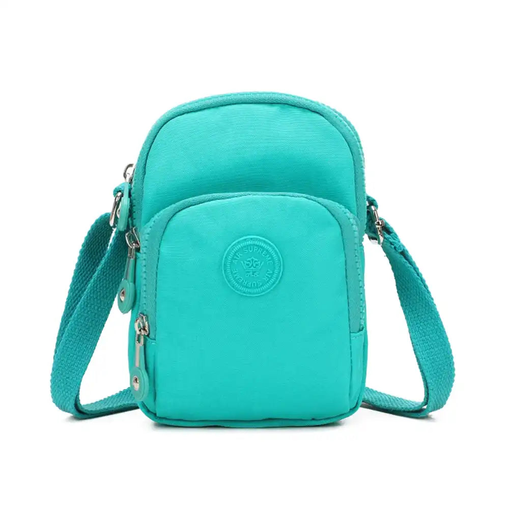 Turquoise crossbody bag with a visible brand logo on a white background