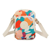 Shoulder bag with bold blue, orange and pink pattern on an off white background. Zipped pockets. Off white strap.